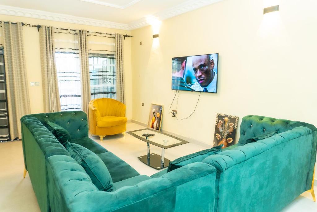 sala de estar con sofá azul y silla amarilla en Vyemma Residence, en Limbe