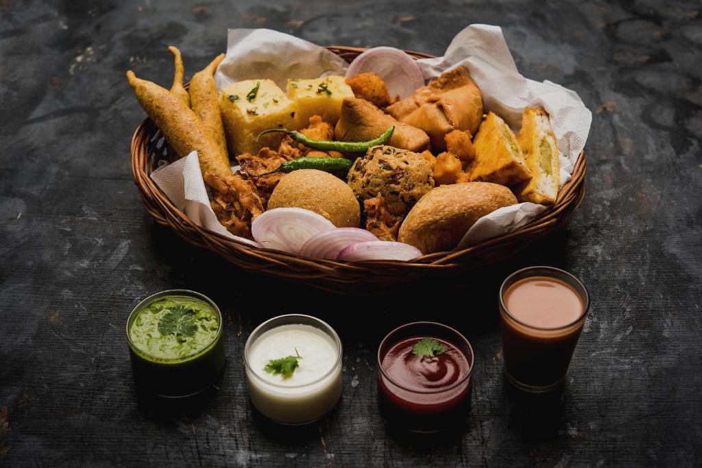 una cesta de comida con patatas fritas, salsas y bebidas en POP Fareeda Homestay 