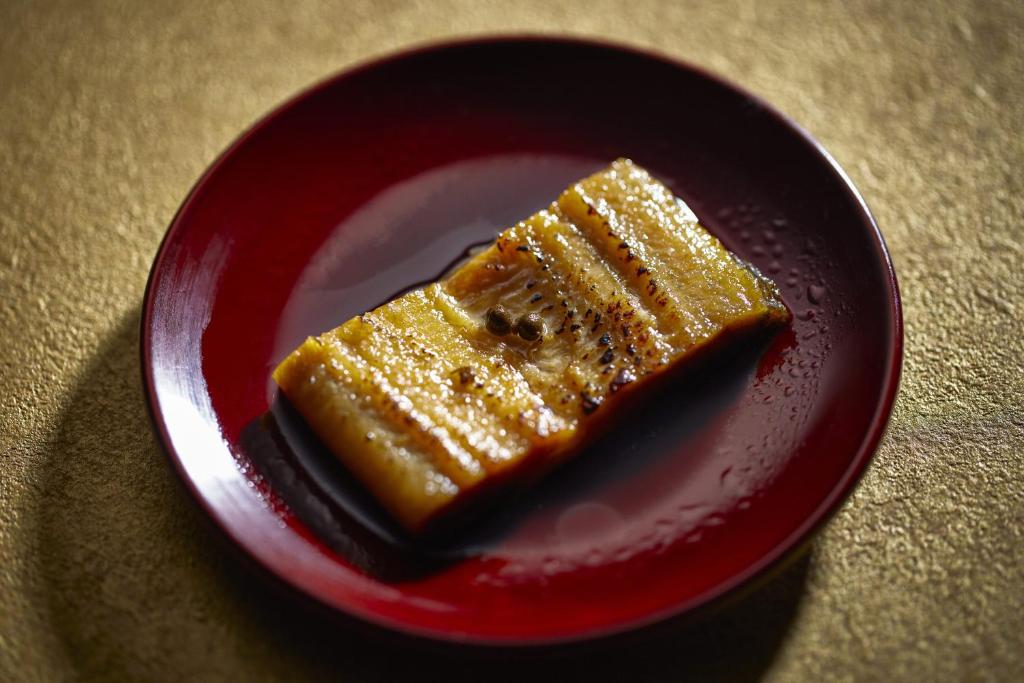 a red plate with a piece of cake on it at Waqoo Naritasanmonzen in Narita