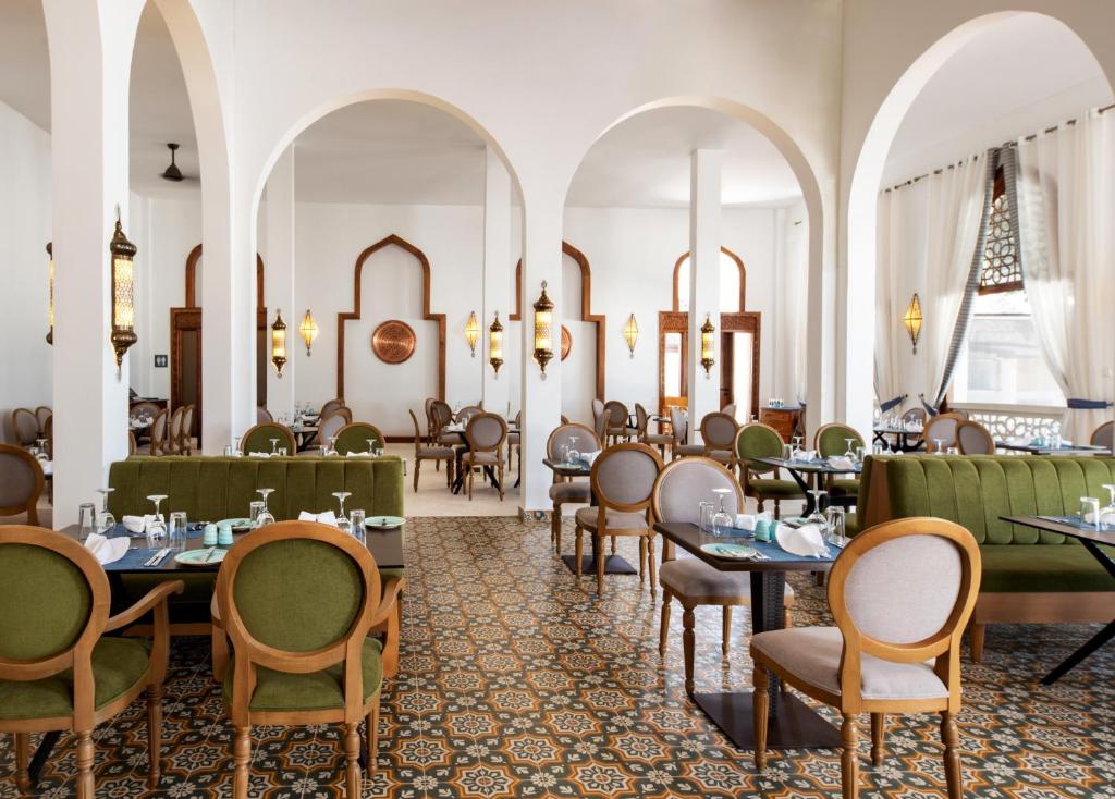 - un restaurant avec des tables et des chaises dans une salle dans l'établissement LUX Marijani Zanzibar, à Pwani Mchangani