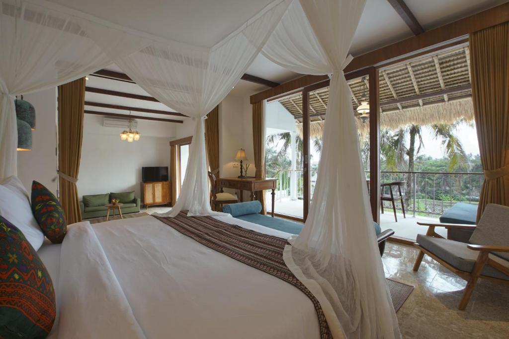 1 dormitorio con 1 cama con dosel en Motama Villa en Ubud