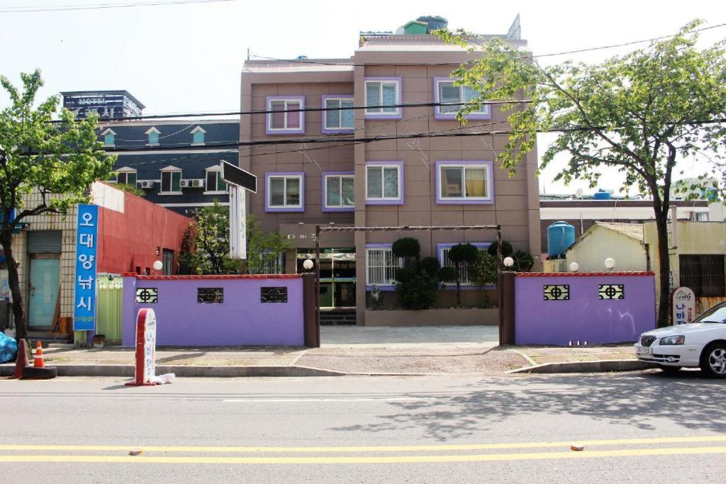 a street with buildings and a car parked on the street at Nabizam Motel in Yeosu