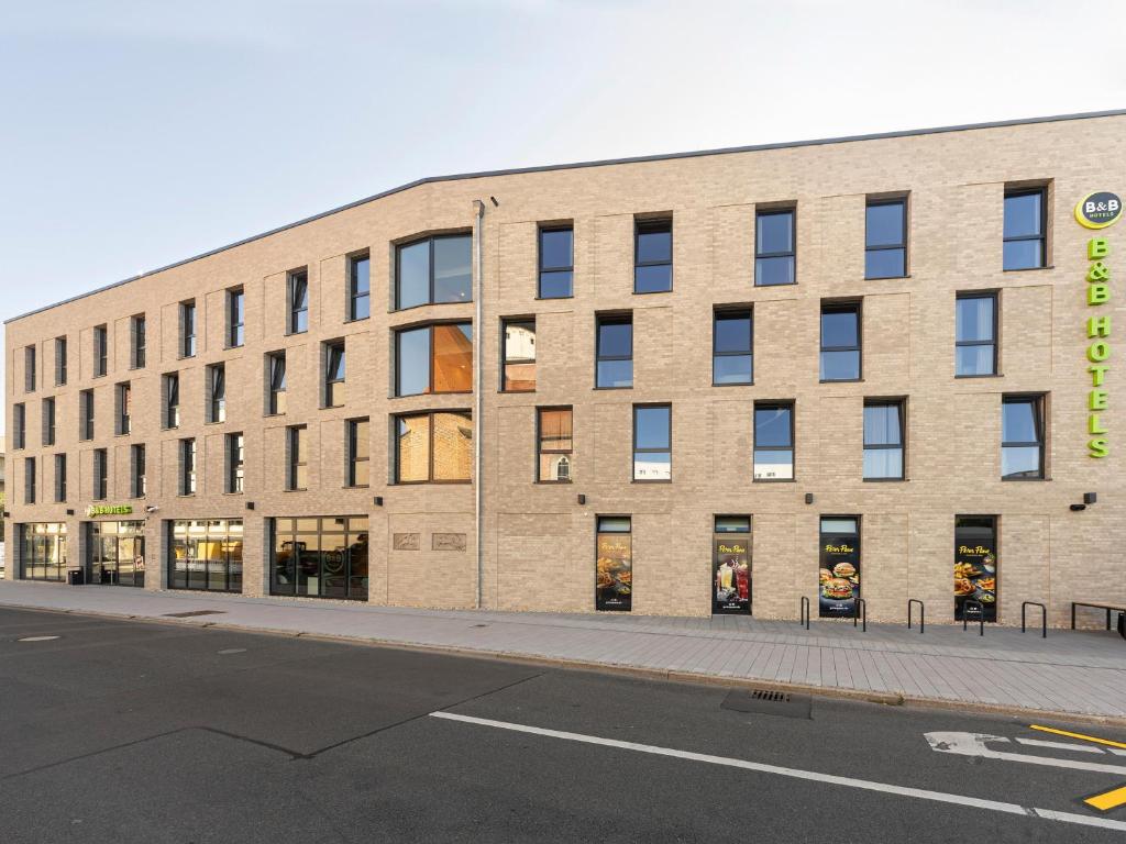 a large brick building with windows on a street at B&B Hotel Dessau in Dessau