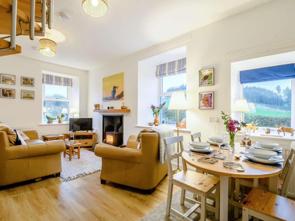 a living room with a table and chairs and a fireplace at 3 Bed in Lockerbie 89406 in Lockerbie