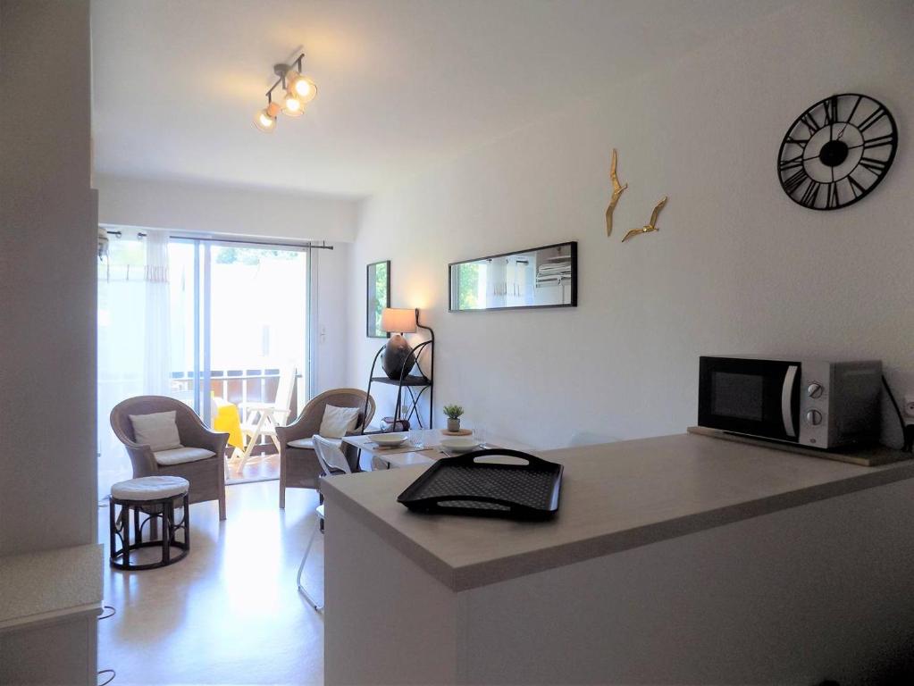 a kitchen and living room with a counter top with a microwave at Saint Georges de Didonne - STUDIO TRES SYMPA - proche plage et centre - in Saint-Georges-de-Didonne