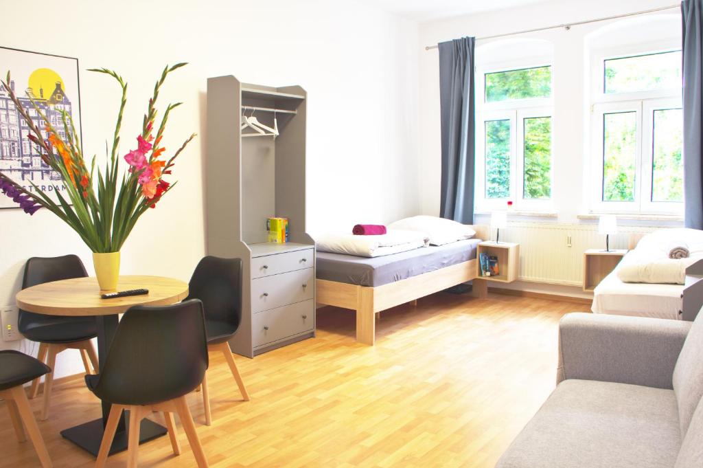 a small bedroom with a bed and a table and chairs at Ara Monteursunterkunft, Ferienwohnung Halle Giebichenstein in Giebichenstein