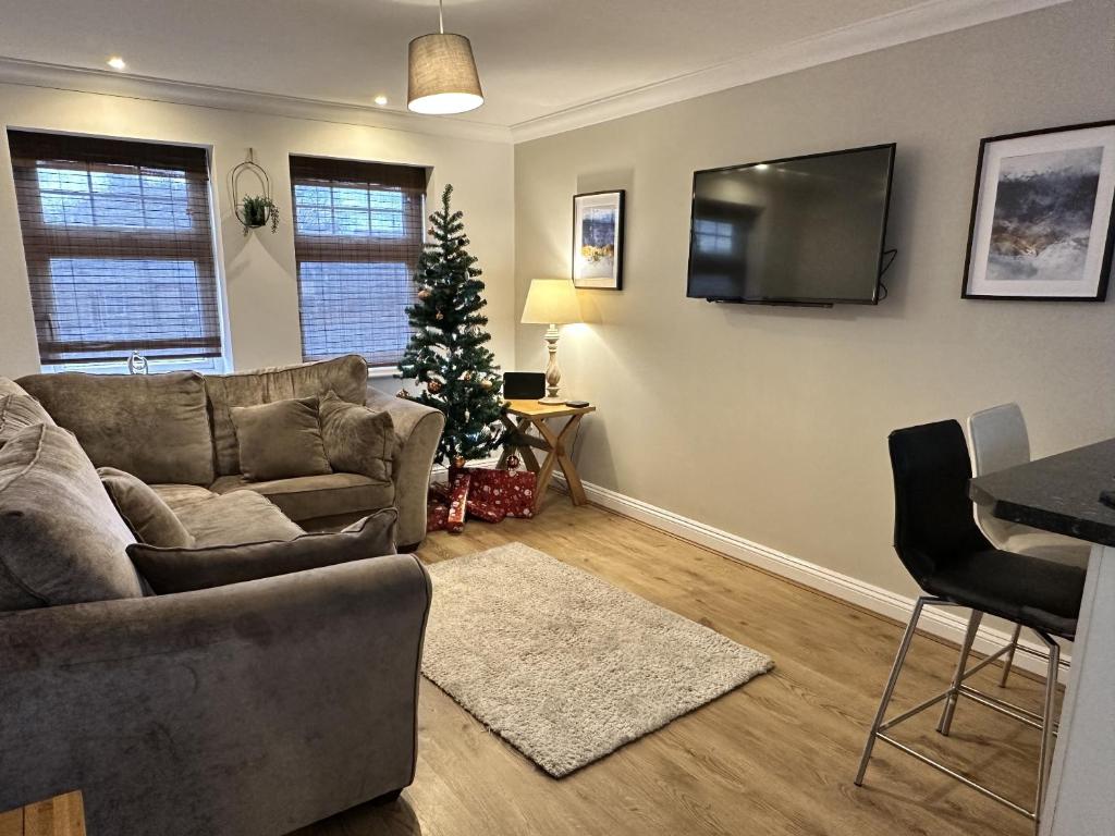 a living room with a couch and a christmas tree at Yew Tree Court in Heswall
