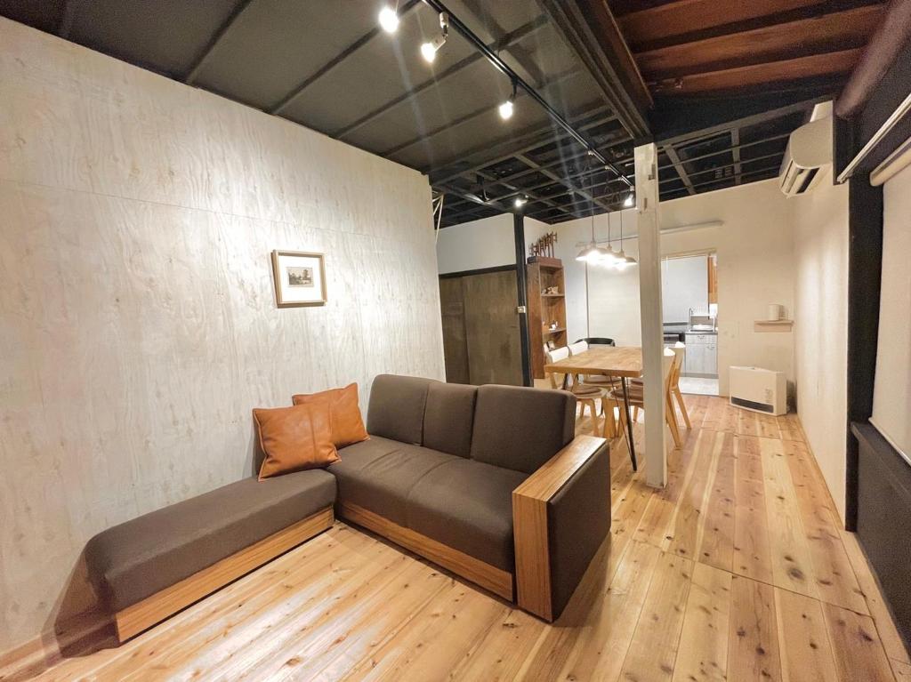 een woonkamer met een bank en een tafel bij HISORI Arts and Stay in Kanazawa