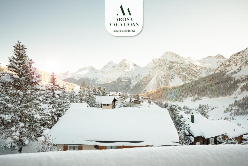 a snow covered roof of a house with mountains in the background at Sillur 2 - Apartment in Innerarosa in Arosa