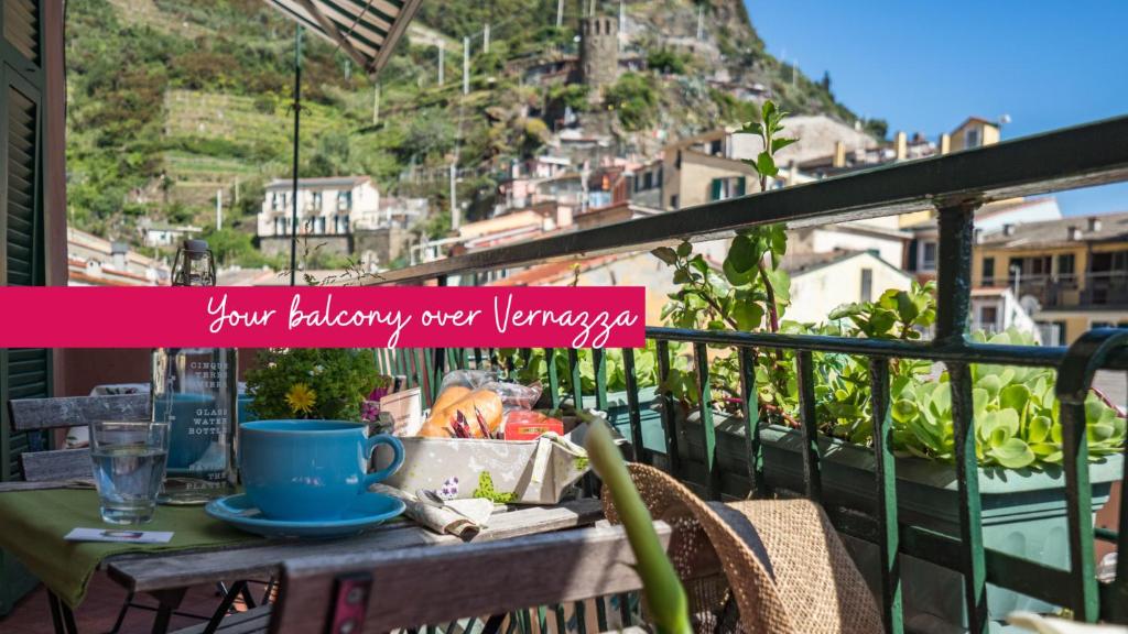 un tavolo su un balcone con vista sulle montagne di Recanissu Apartment with balcony & AC a Vernazza