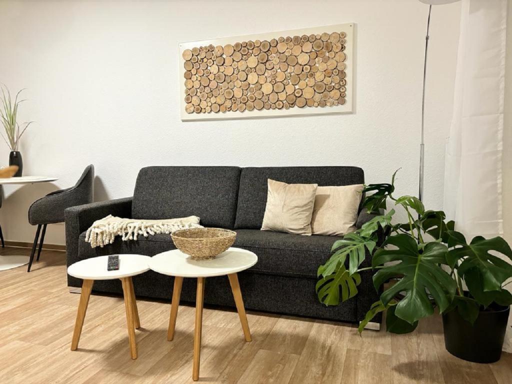 ein Wohnzimmer mit einem Sofa und 2 Tischen in der Unterkunft Charming Homes - Studio 20 in Wolfsburg
