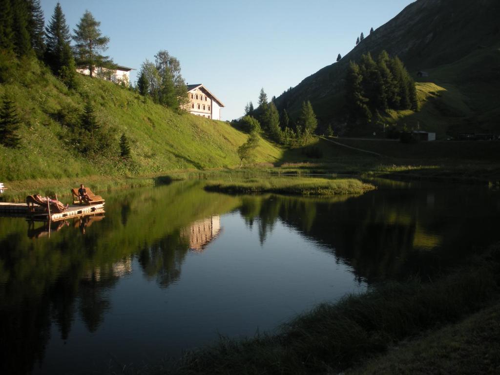 a body of water with two people on a boat w obiekcie Haus Hubertus w mieście Warth am Arlberg