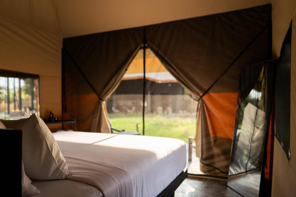 a bedroom with a bed and a tent at Toteme Glamping and Hot Spring Kintamani in Kubupenlokan
