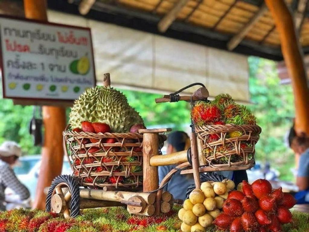 un modelo de un puesto de frutas con dos cestas en una bicicleta en Holiday Inn & Suites Rayong City Centre, an IHG Hotel, en Rayong