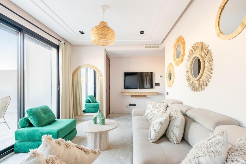 TTHOLIDAYS Cosy Apartment Casablanca City Center في الدار البيضاء: غرفة معيشة مع أريكة بيضاء وكراسي خضراء