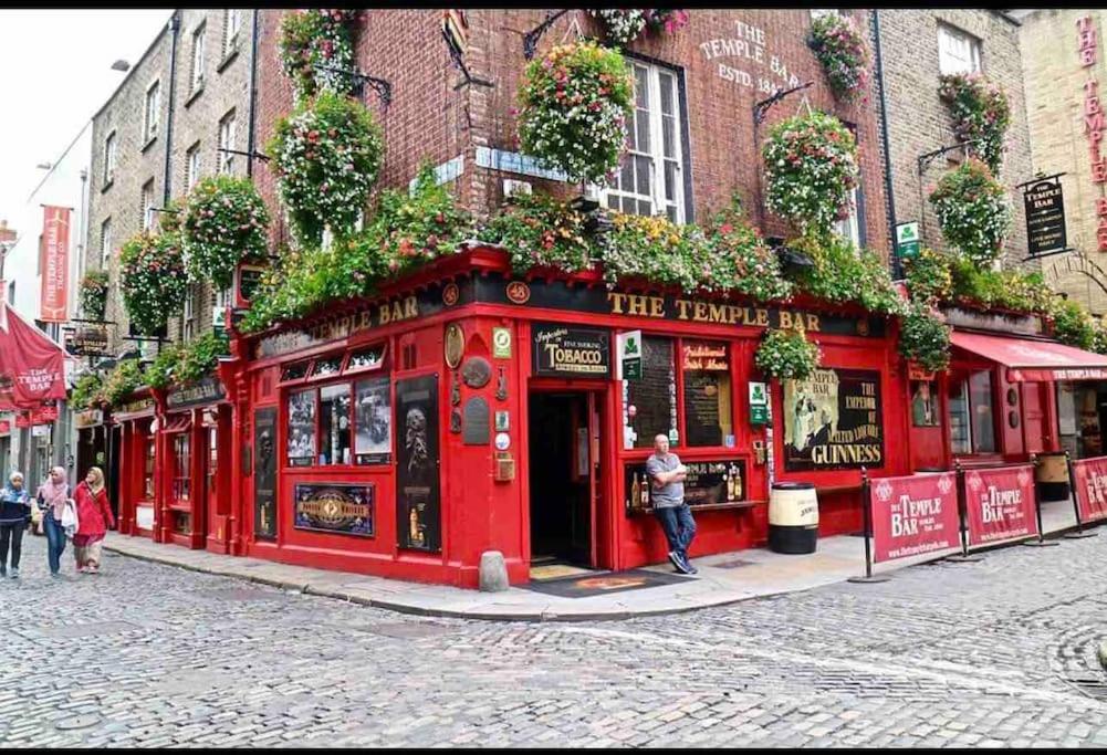 a red building on a street with people standing outside at In Dublin's Best Tourist Spot Temple Bar Fully Renovated in Dublin