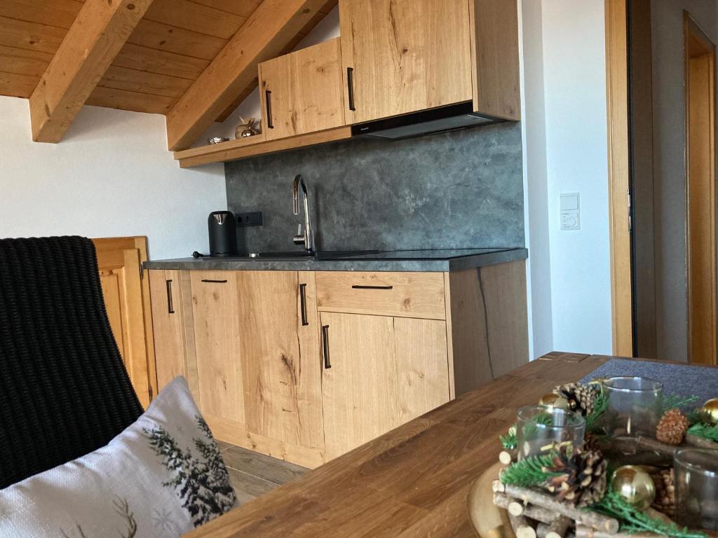 eine Küche mit Holzschränken und einem Holztisch in der Unterkunft Ferienwohnungen LARA Wohnung 3 in Wallgau