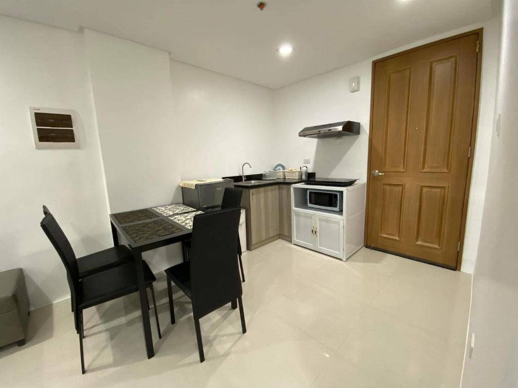 cocina con mesa y sillas en una habitación en Room 703 Pontefino Hotel, en Batangas