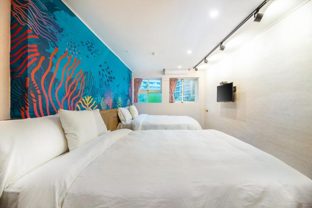 礁溪鄉的住宿－帝王行旅，一间卧室设有两张床,墙上挂着一幅画