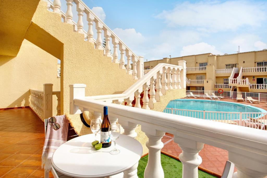 einen Balkon mit einem Tisch und einer Flasche Wein in der Unterkunft Liomor Luxury in Caleta de Fuste