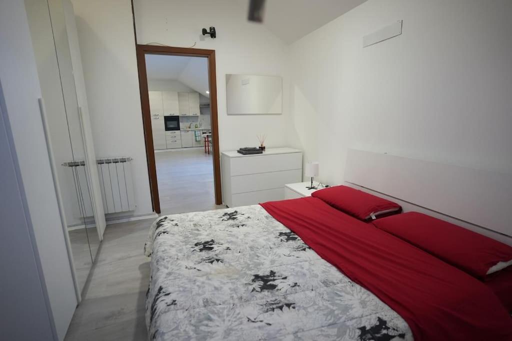 - une chambre dotée d'un lit avec des draps rouges et un miroir dans l'établissement ClaRo Appartamento intero, à Limbiate