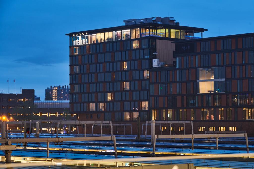 ユトレヒトにあるInntel Hotels Utrecht Centreの街中の明かりが灯っている高層ビル