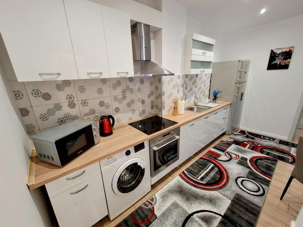 a kitchen with a microwave and a washer and dryer at Casa Feli in Braşov