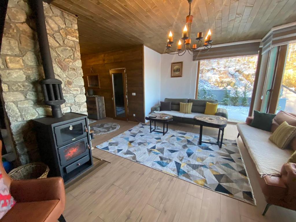 a living room with a wood stove and a couch at Villa Gjelbër in Prizren