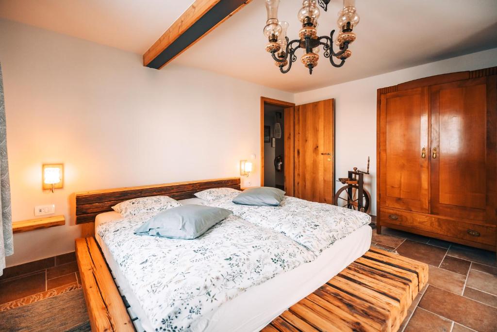 ein Schlafzimmer mit einem großen Bett und einem Kronleuchter in der Unterkunft Posest Kunigunda in Šmartno v Rožni Dolini