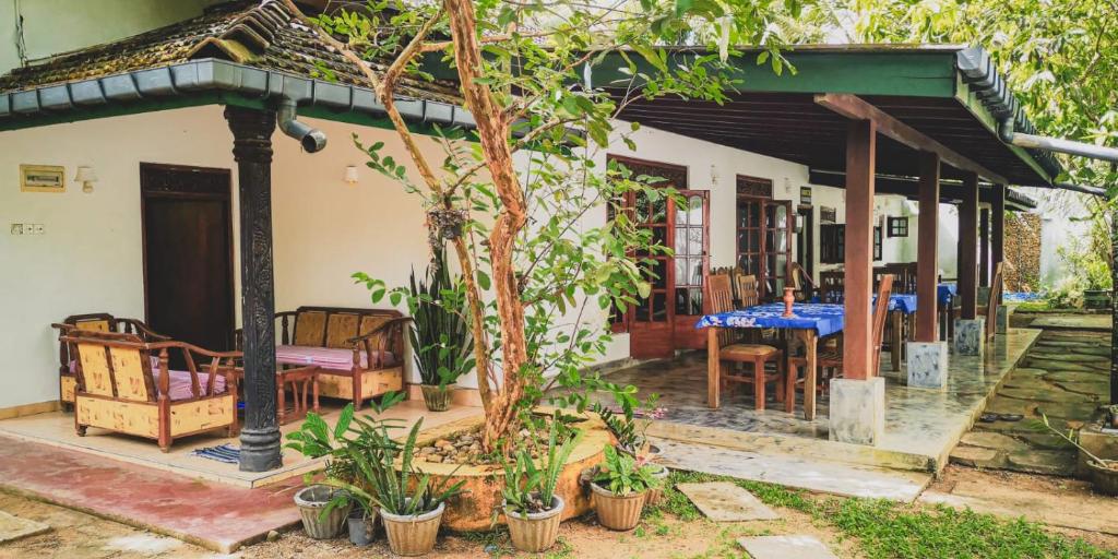 a house with a porch with a table and chairs at Weligama Bay Eco Villa in Weligama