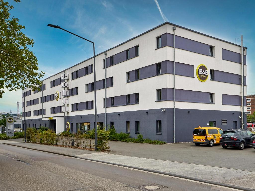 um edifício com uma carrinha amarela estacionada em frente em B&B Hotel Trier em Trier