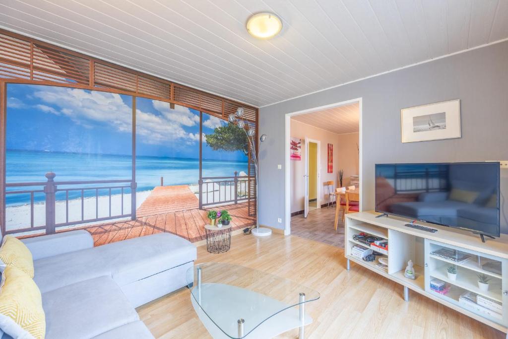 Una sala de estar con vista al mar. en La Maresquerie, en Grandcamp-Maisy