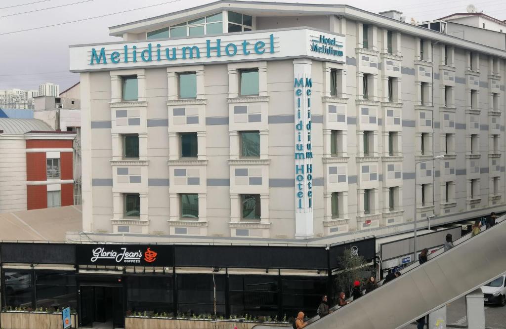 ein großes weißes Gebäude mit Hotelschild drauf in der Unterkunft Melidium Hotel in Beylikdüzü