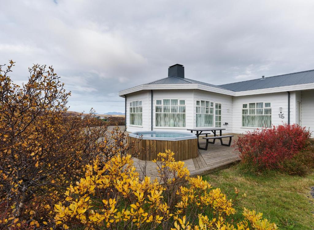 ein weißes Haus mit einer Terrasse mit einem Picknicktisch in der Unterkunft Hotel Grimsborgir by Keahotels in Ásborgir