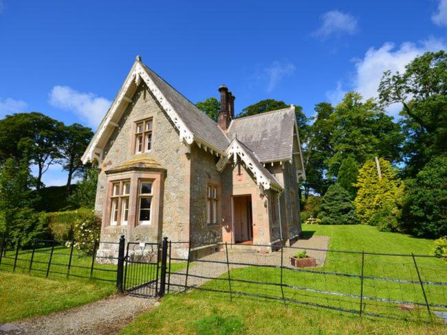 an old house with a fence in front of it at 2 Bed in Lochgilphead AG577 in Kilmartin