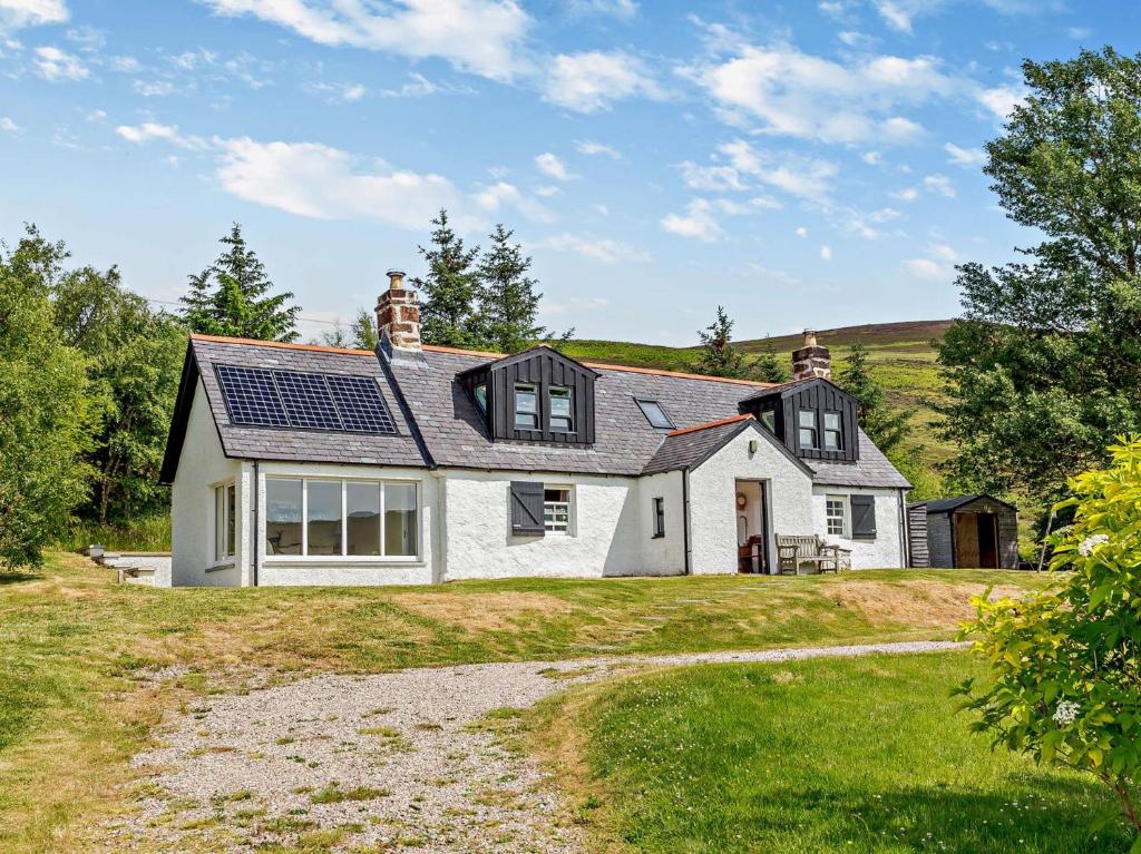 a white house with solar panels on the roof at 3 bed in Helmsdale SU192 in Helmsdale
