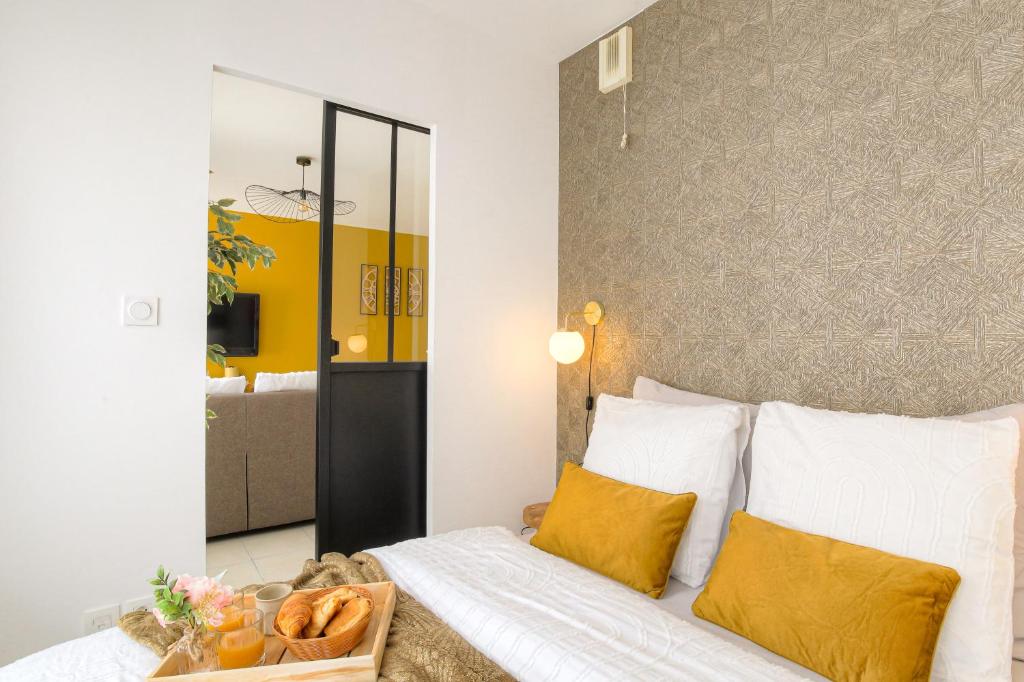 - une chambre avec un lit et un plateau de pain dans l'établissement LE LOUIS D’OR -Accès facile Gare/Eurexpo/Aéoroport, à Villeurbanne