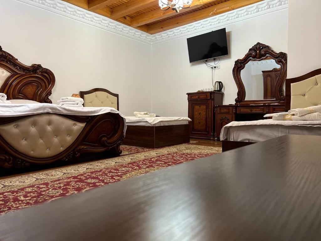 a large room with two beds and a television at GOLDEN MINARET by Terrace in Bukhara