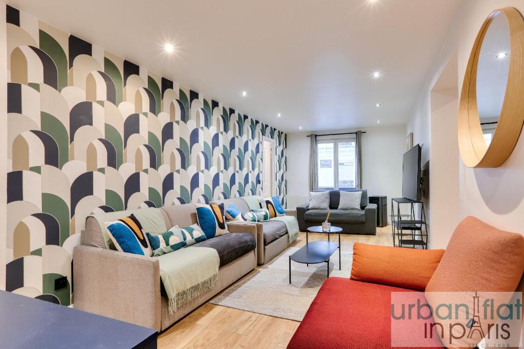 una sala de estar con sofás, sillas y una pared en Urban Flat 103 - Spacious Flat near Grands Boulevards en París
