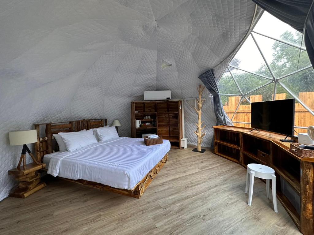 清道的住宿－Lhong Chiang Dao Glamping หลงเชียงดาว，一间卧室配有一张床,帐篷内配有电视