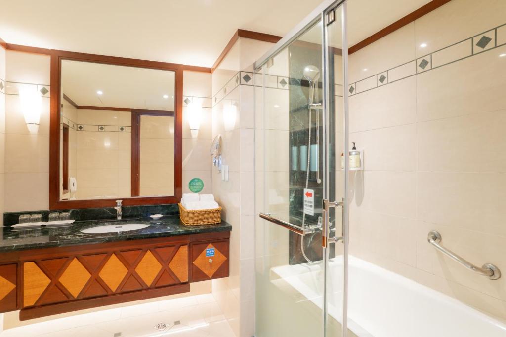 a bathroom with a glass shower and a sink at Formosan Naruwan Hotel in Taitung City