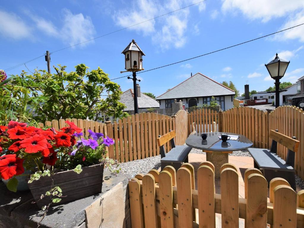 a backyard with a wooden fence and a table and flowers at 1 bed property in Wadebridge Cornwall 42756 in Wadebridge