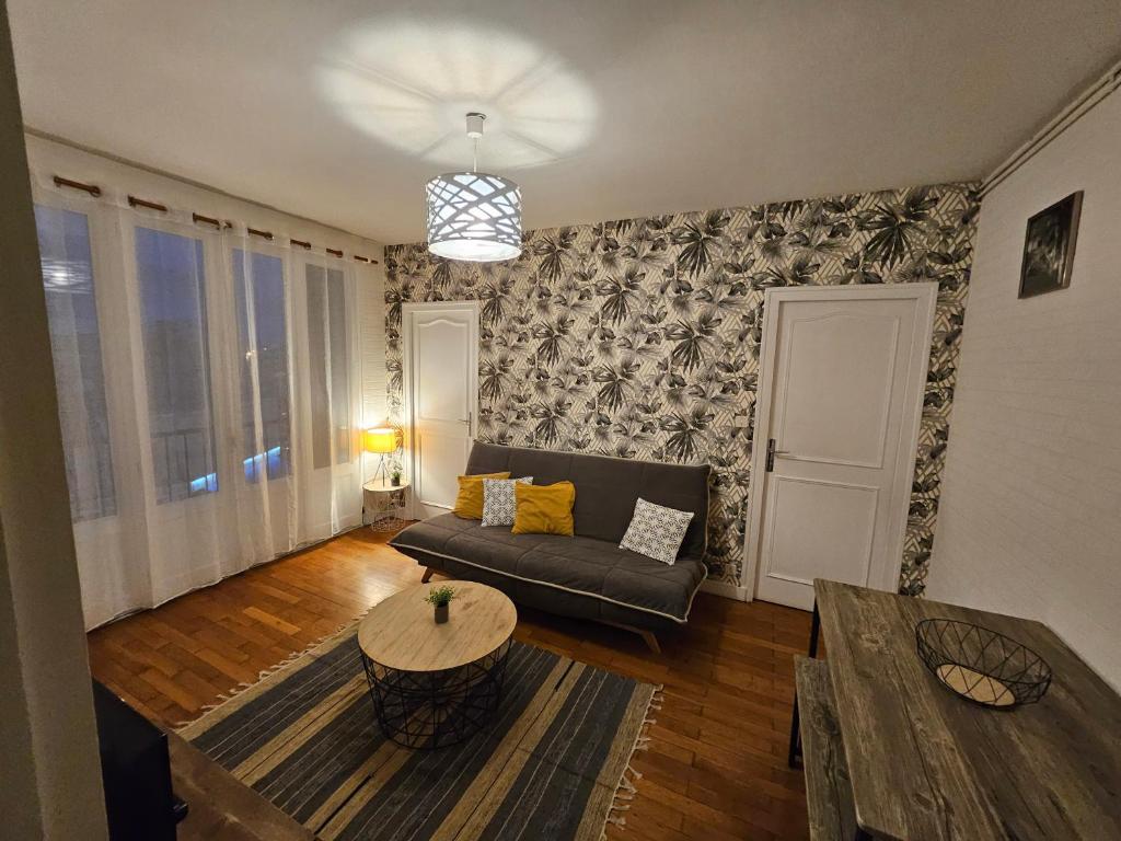 uma sala de estar com um sofá e uma mesa em Appartement T2, très lumineux - à 100m de la gare. em Limoges