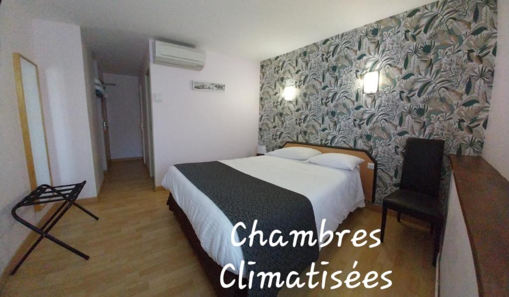 een hotelkamer met een bed en een muur bij Hôtel Restaurant du Lauragais LOGIS DE FRANCE in Villefranche-de-Lauragais