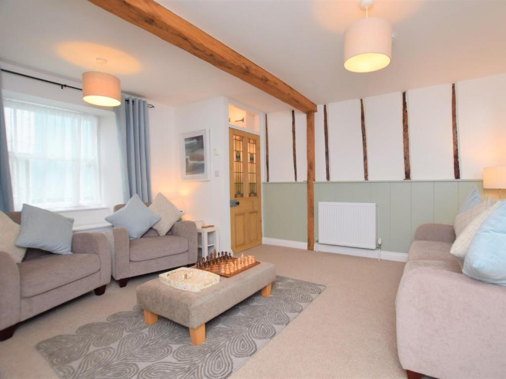 a living room with two couches and a table at 2 Bed in Appledore 53994 in Appledore
