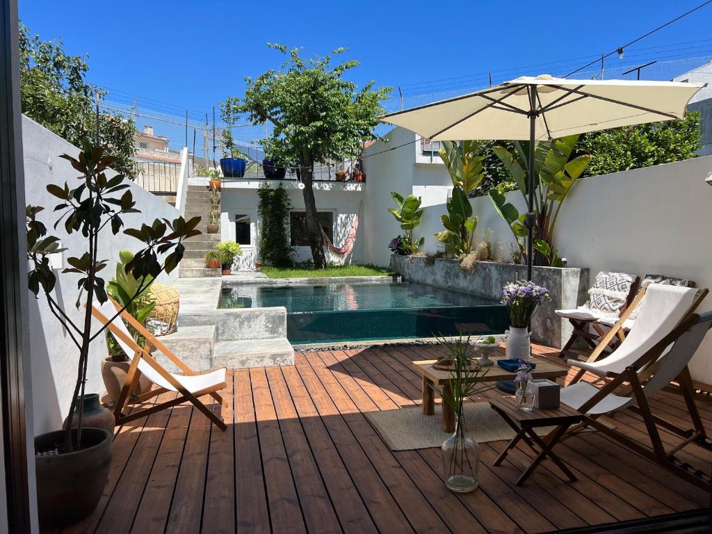 um pátio com uma piscina, cadeiras e um guarda-sol em FLH Secluded Porto Haven with Pool no Porto