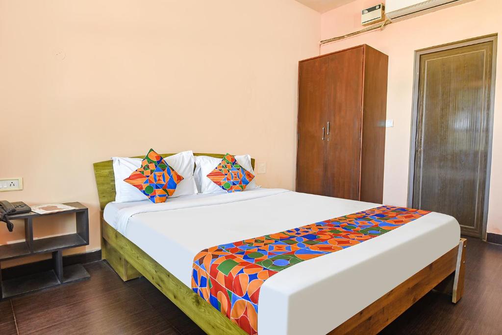 1 dormitorio con 1 cama grande y armario de madera en FabEscape Aqualura Verem With Swimming Pool en Nerul