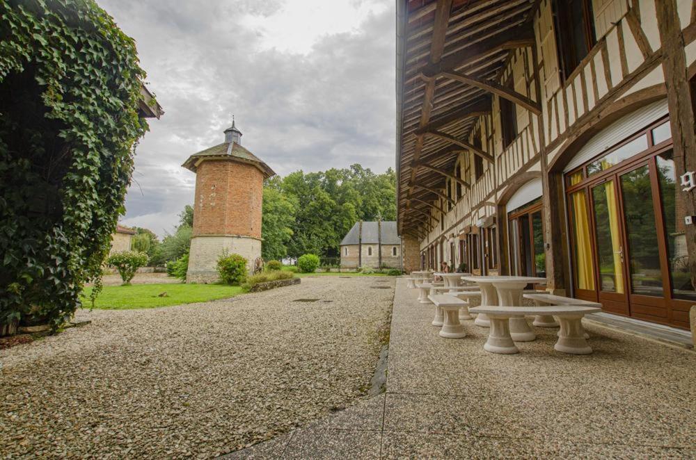 a row of picnic tables next to a building with a tower at Le gite du chateau 1 