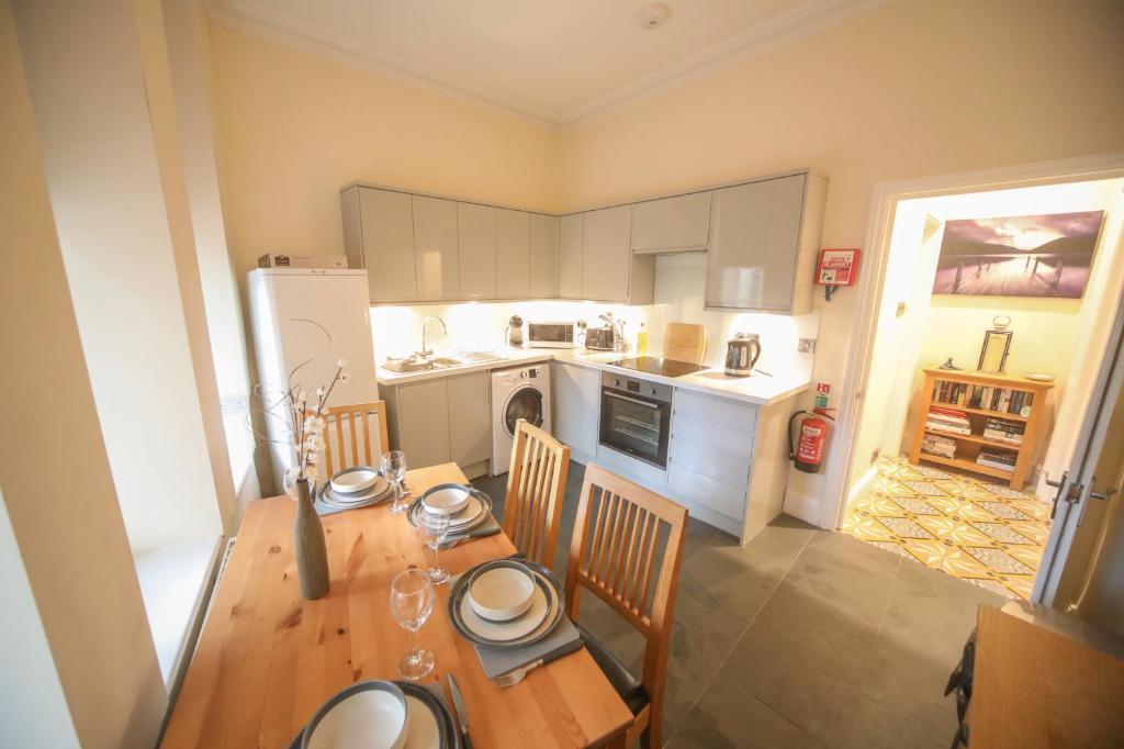 a kitchen with a table and chairs and a refrigerator at lfracombe Holiday Apartment Close to Tunnels Beaches in Ilfracombe