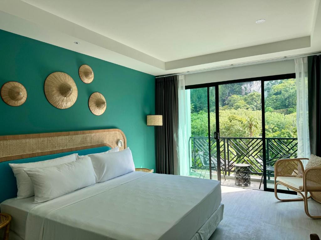 a bedroom with a bed with a blue wall at Keereen Resort - Ao Nang Krabi in Ao Nang Beach